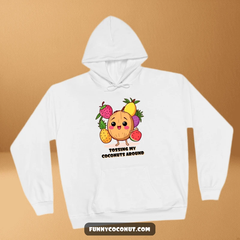 Funny hoodie depicting a joyful coconut character juggling three ripe tropical fruits, perfect for cozy, humorous wear.